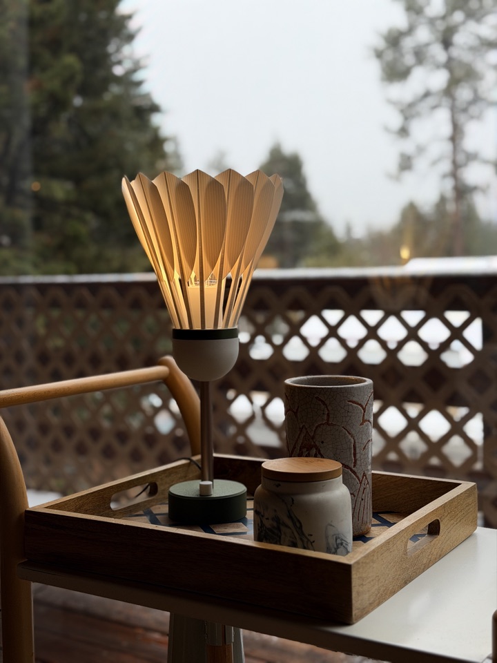 Shuttlecock Lamp glowing beside a bright window